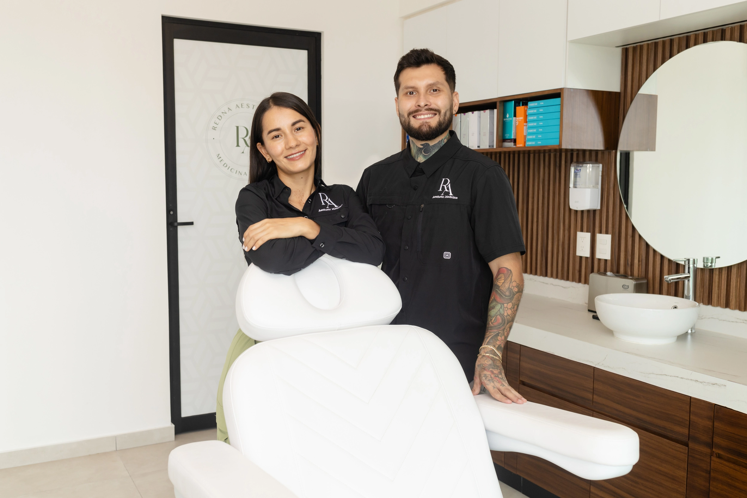 Dr. Darío Chavoya and a team member standing next to a treatment chair at Redna Aesthetics